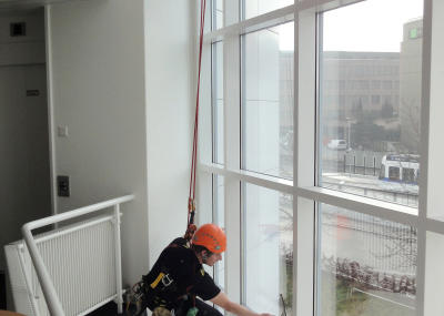 Industriekletterer bei Glasreinigung am hängenden Seil, Arbeit am Seil