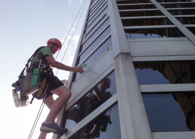 Industriekletterer bei Glasreinigung am hängenden Seil, Arbeit am Seil in der Höhe