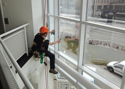 Industriekletterer bei Glasreinigung am hängenden Seil, Arbeit am Seil
