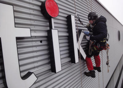 Leuchtwerbung montieren am Seil an schwer zugänglicher Stelle